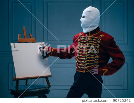 Young man, medieval hussar wearing white colors balaclava on dark blue background. Concept of comparison of eras, art, history. Creative collage. Young man, medieval hussar wearing white colors balaclava on dark blue background. Concept of comparison of eras, art, history. Creative collage. 90715241