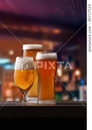 Three different glasses of beer on counter in pub. 90717524