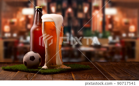 Buttle and glass of beer, soccer ball on green grass 90717541