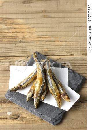 A bird's-eye view of fried silver-stripe round herring on a slate plate and top paper A bird's-eye view of fried silver-stripe round herring on a slate plate and top paper 90717721