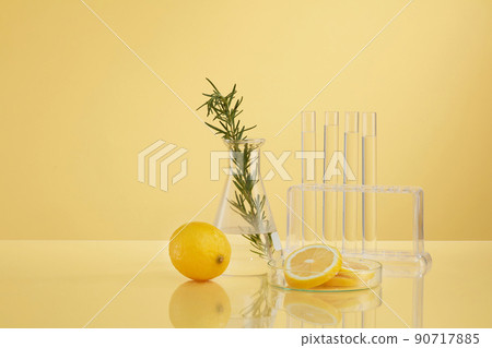 Front view of transparent podium with lemon laboratory equipment and green leaf in beige background science content Front view of transparent podium with lemon laboratory equipment and green leaf in beige background science content 90717885