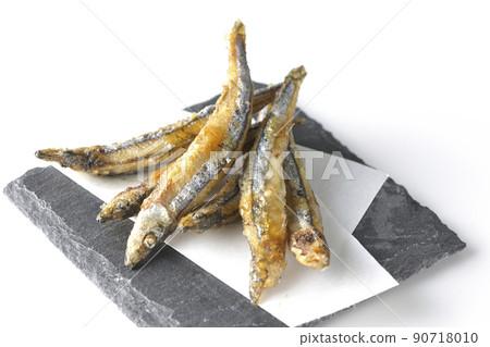 Slate plate, fried silver-stripe round herring on top paper taken on a white background 90718010