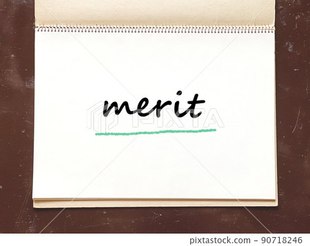 Merit text page of an old sketchbook opened on a desk_overview 90718246