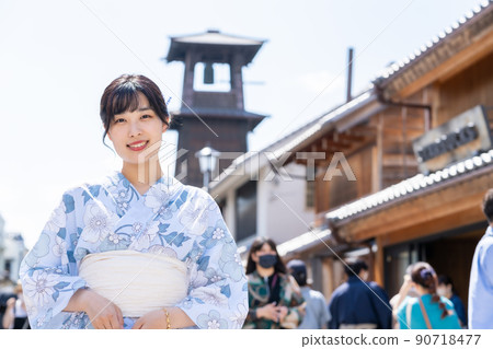 A young woman walking around the town of Kura wearing a yukata 90718477