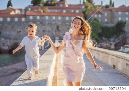 Mother and son tourists on background of beautiful view St. Stephen island, Sveti Stefan on the Budva Riviera, Budva, Montenegro. Travel to Montenegro concept 90718504