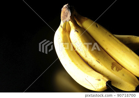 Take a bunch of bananas on a black background Take a bunch of bananas on a black background 90718700