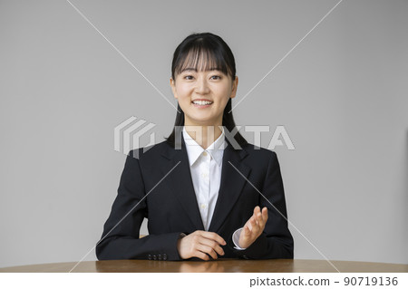 一位穿著西裝的年輕女子看著相機說話的肖像 90719136
