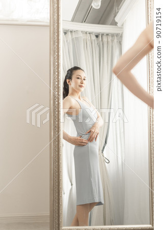 A woman who cares about her body shape while looking in the mirror 90719154