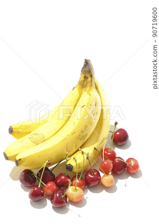A bunch of bananas and a lot of cherries shot with a shadow and a white background A bunch of bananas and a lot of cherries shot with a shadow and a white background 90719600