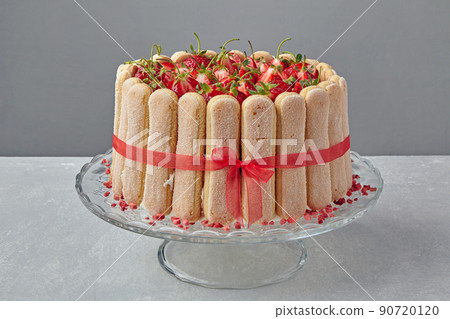 Cake dessert with strawberries, savoiardi cookies and mascarpone tied with a red ribbon Cake dessert with strawberries, savoiardi cookies and mascarpone tied with a red ribbon 90720120