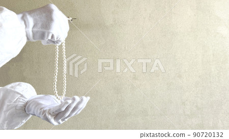 Hands in white gloves with a pearl necklace_wide 90720132