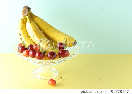 A bunch of bananas on the cake stand and lots of cherries. Assorted fruits A bunch of bananas on the cake stand and lots of cherries. Assorted fruits 90720147