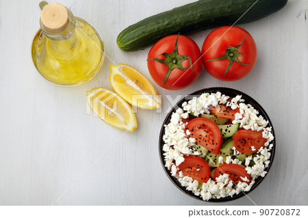 Bowl with chopped tomatoes and cucumbers, cottage cheese and black cumin 90720872