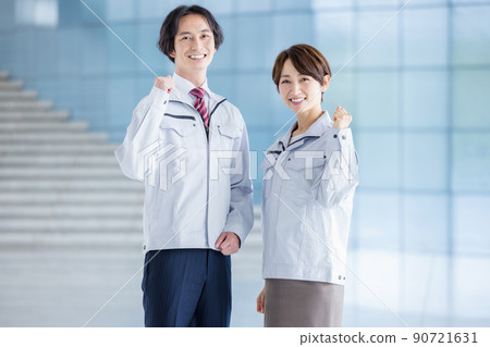 Male and female engineers in work clothes in the office 90721631