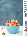 large yellow pink cherries in a blue bowl 90722377