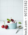 large cherries with greek yogurt and mint in a blue bowl 90722382