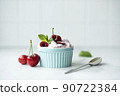 cherries with homemade greek yogurt and mint in a blue bowl 90722384