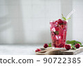 cocktail with cherry juice, mint, and ice in a glass, copy space 90722385