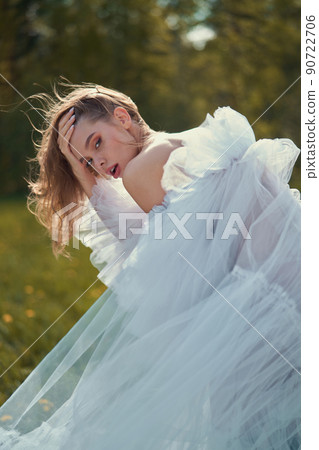 Sexy blonde in a chic classic dress posing in nature. Sexy blonde in a chic classic dress posing in nature. 90722706