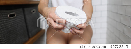 Woman sitting on toilet and hold toilet paper in hands Woman sitting on toilet and hold toilet paper in hands 90722845