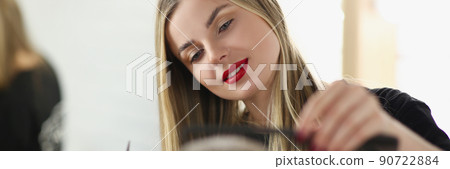 Female hairstylist with scissors and hairbrush styling haircut for male client Female hairstylist with scissors and hairbrush styling haircut for male client 90722884