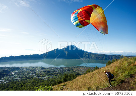 Paraglider starting from Batur volcano. Bali, Indonesia Paraglider starting from Batur volcano. Bali, Indonesia 90723162