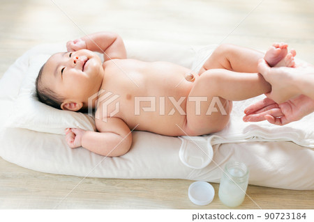 Applying a moisturizer to the buttocks of a smiling baby, diaper care, diaper rash, diaper dermatitis, 2 months old Applying a moisturizer to the buttocks of a smiling baby, diaper care, diaper rash, diaper dermatitis, 2 months old 90723184