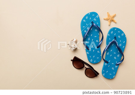 Summer travel concept. Flip flops, sunglasses and starfish on white. Top view on colored background Summer travel concept. Flip flops, sunglasses and starfish on white. Top view on colored background 90723891
