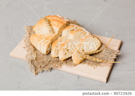 Assortment of freshly sliced baked bread with napkin on rustic table top view. Healthy unleavened bread. French bread slice Assortment of freshly sliced baked bread with napkin on rustic table top view. Healthy unleavened bread. French bread slice 90723926