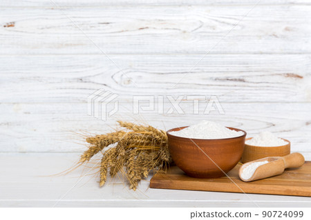 Flat lay of Wheat flour in wooden bowl with wheat spikelets on colored background. world wheat crisis 90724099