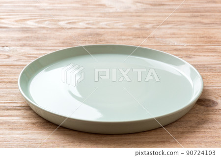 Perspective view of empty blue plate on wooden background. Empty space for your design 90724103