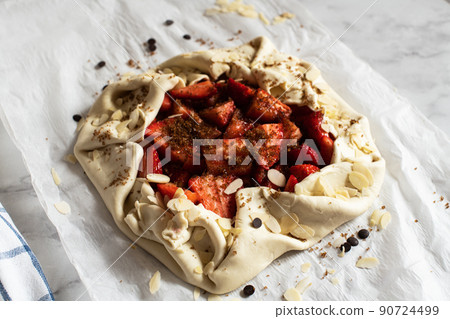 Summer strawberry galette with almond flakes in making. Food preparation concept. 90724499