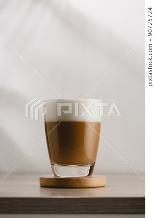 Cappuccino in a glass cup on a wooden table Cappuccino in a glass cup on a wooden table 90725724