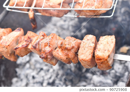 Grilled pork meat in a barbecue net with spices Grilled pork meat in a barbecue net with spices 90725908
