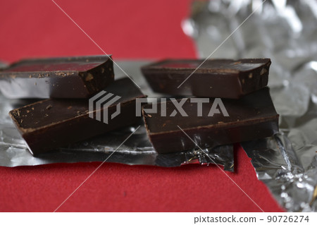 Chocolates on foil on a red background. Delicious candies. 90726274