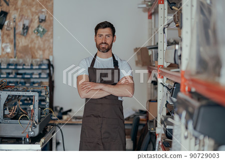 Portrait of business owner standing on workshop of coffee machines warehouse 90729003