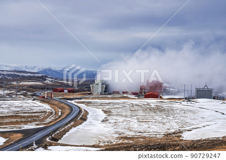Steaming cooling tower at Krafla geothermal power plant by road against sky 90729247