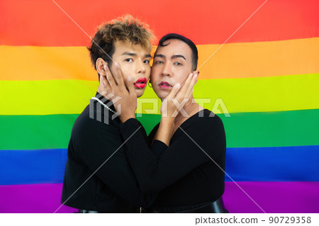 Photo of asian Transgender couple standing together on the pride flag rainbow background lgbtq and lgbtq+ concept 90729358