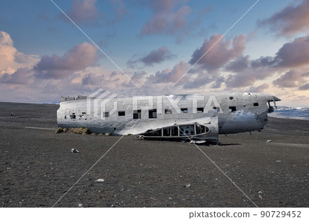 Abandoned damaged plane wreck at black sand beach in Solheimasandur at sunset 90729452