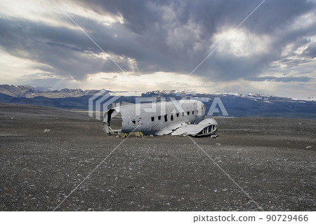 Broken airplane wreck at famous black beach in Solheimasandur against cloudy sky Broken airplane wreck at famous black beach in Solheimasandur against cloudy sky 90729466