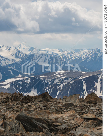 Dramatic aerial view to large snow mountain range under changeable rainy cloudy sky. Bright atmospheric alpine scenery with high snowy mountain peak in low clouds. Dramatic aerial view to large snow mountain range under changeable rainy cloudy sky. Bright atmospheric alpine scenery with high snowy mountain peak in low clouds. 90729564