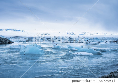 Beautiful icebergs floating in Jokulsarlon glacier lagoon against blue sky Beautiful icebergs floating in Jokulsarlon glacier lagoon against blue sky 90729641