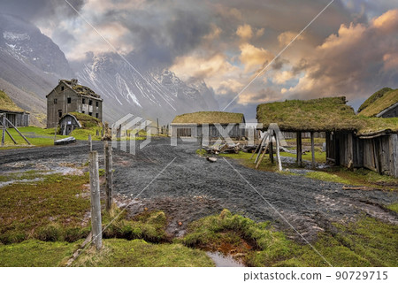 Tiretracks by traditional houses in Viking village against cloudy sky at sunset Tiretracks by traditional houses in Viking village against cloudy sky at sunset 90729715