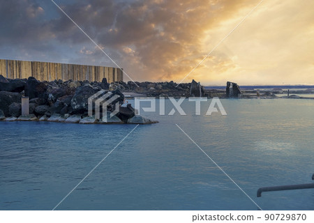 Natural geothermal spa in blue lagoon against cloudy sky during sunset Natural geothermal spa in blue lagoon against cloudy sky during sunset 90729870