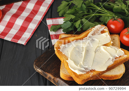 Simple breakfast. Toasted bread covered with butter 90729994