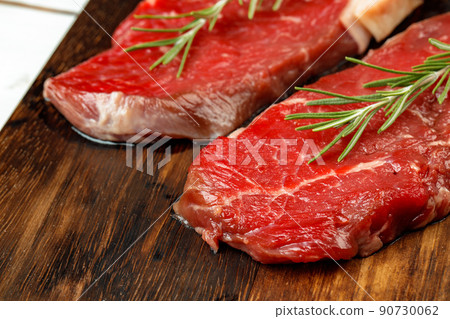 Barbecue veal steaks with rosemary on wooden board Barbecue veal steaks with rosemary on wooden board 90730062