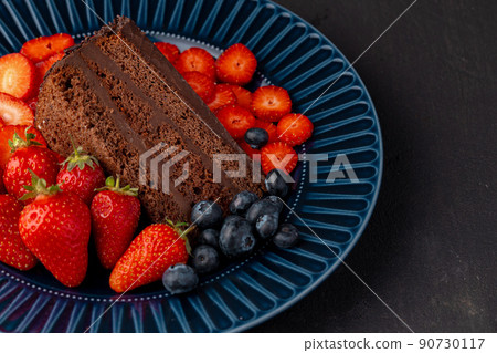 Slice of tasty chocolate cake with cut strawberries Slice of tasty chocolate cake with cut strawberries 90730117
