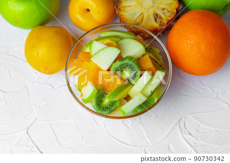Glass bowl with fresh fruit pieces close up 90730342