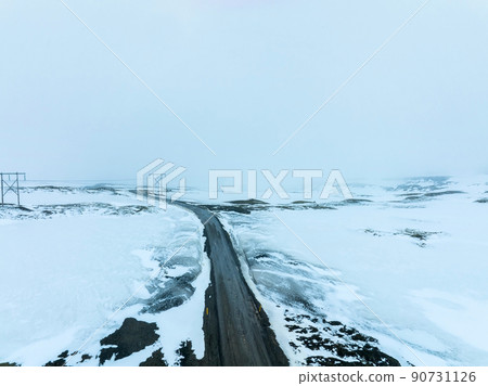 Endless road into the cloudy mountains and hills of Iceland during sunny cloudy weather. Endless road into the cloudy mountains and hills of Iceland during sunny cloudy weather. 90731126
