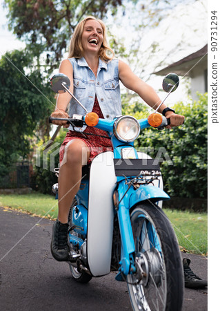 Young woman ride on retro motorbike around tropical island 90731294